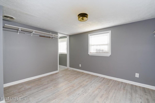 unfurnished bedroom with light hardwood / wood-style floors and a textured ceiling