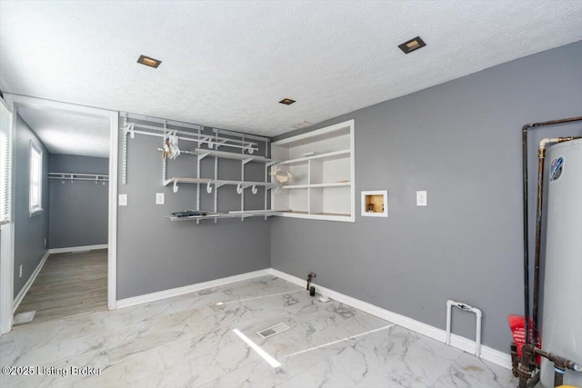 laundry room featuring washer hookup, water heater, a textured ceiling, and gas dryer hookup