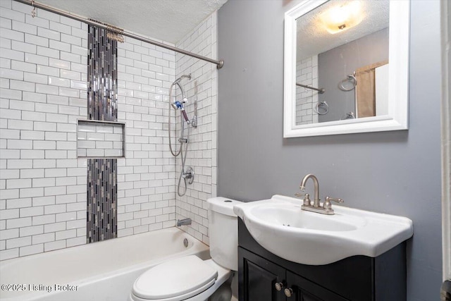 full bathroom with vanity, tiled shower / bath, toilet, and a textured ceiling