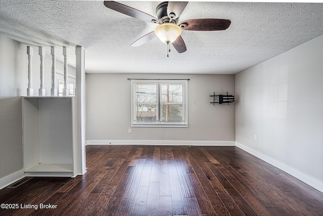 spare room featuring ceiling fan, dark wood-type flooring, and a textured ceiling