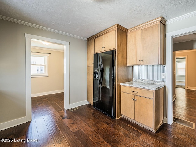 kitchen with crown molding, black fridge, a textured ceiling, and dark hardwood / wood-style flooring