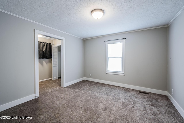 carpeted empty room featuring crown molding and a textured ceiling