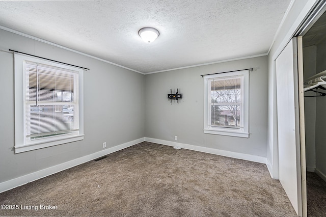 unfurnished bedroom featuring crown molding, carpet flooring, a closet, and a textured ceiling