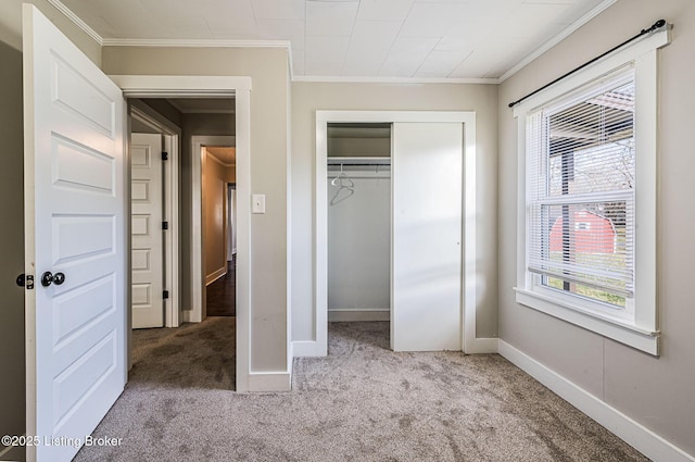 unfurnished bedroom featuring ornamental molding, light colored carpet, and a closet