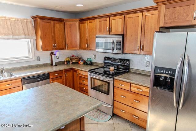 kitchen with light tile patterned flooring, stainless steel appliances, sink, and decorative backsplash