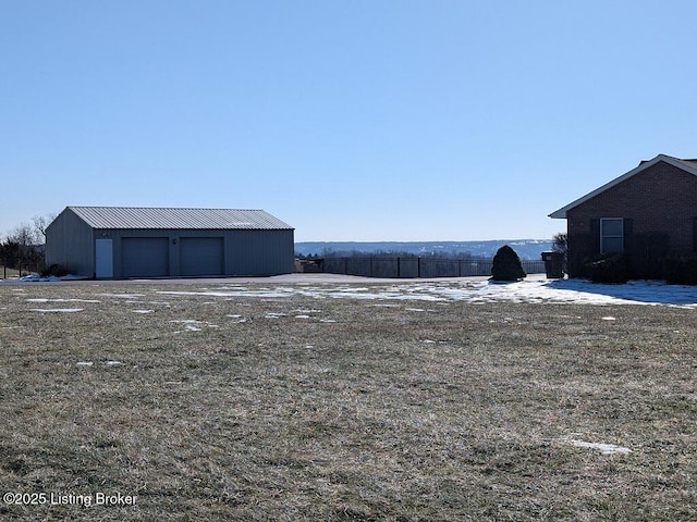 view of yard with a garage and an outbuilding