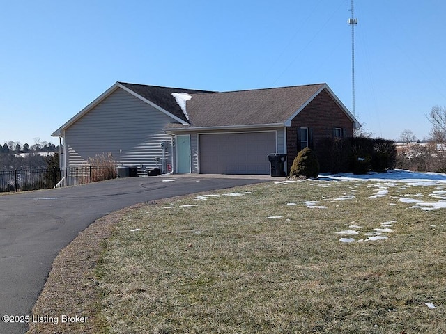 view of home's exterior featuring a garage, a lawn, and central air condition unit