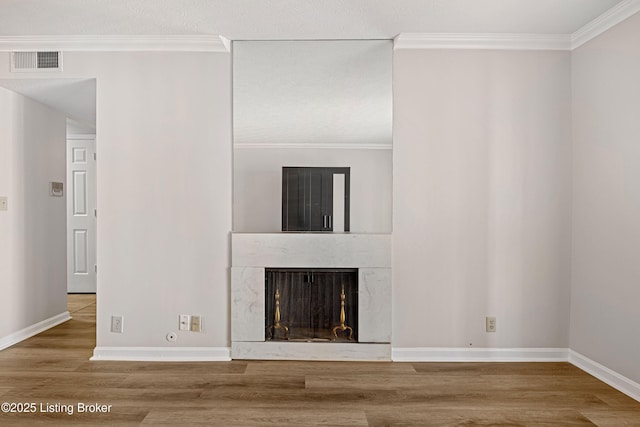 unfurnished living room with hardwood / wood-style floors, a fireplace, and ornamental molding