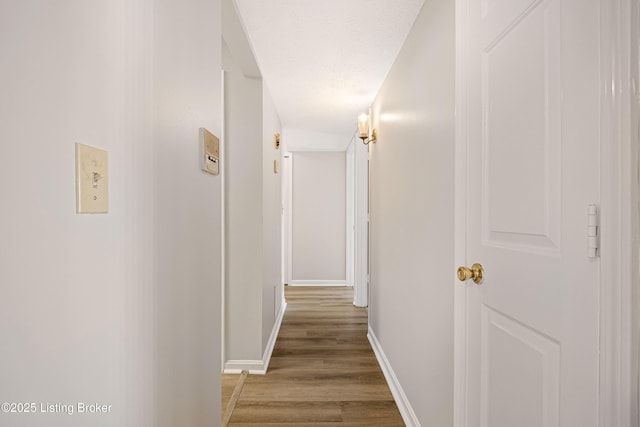 hallway with hardwood / wood-style floors and a textured ceiling