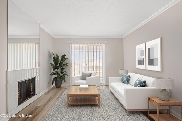 living room featuring ornamental molding, a textured ceiling, and light hardwood / wood-style flooring