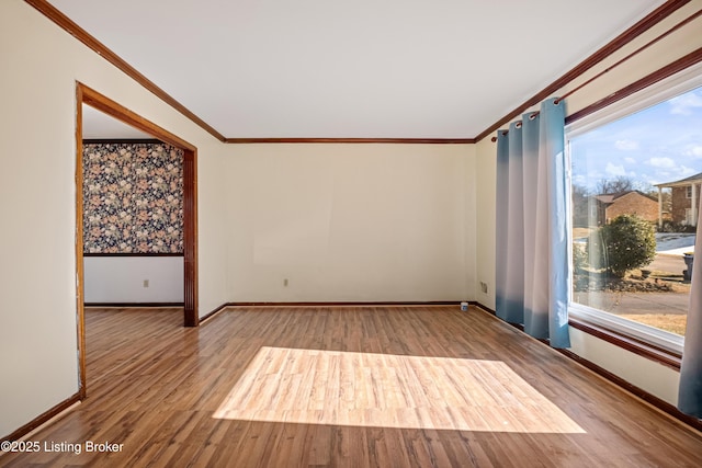 empty room featuring hardwood / wood-style flooring and crown molding