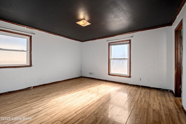 empty room featuring crown molding and light wood-type flooring