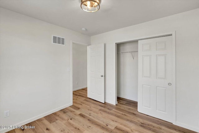 unfurnished bedroom featuring a closet and light hardwood / wood-style flooring