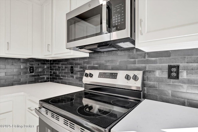 kitchen featuring tasteful backsplash, stainless steel appliances, and white cabinets