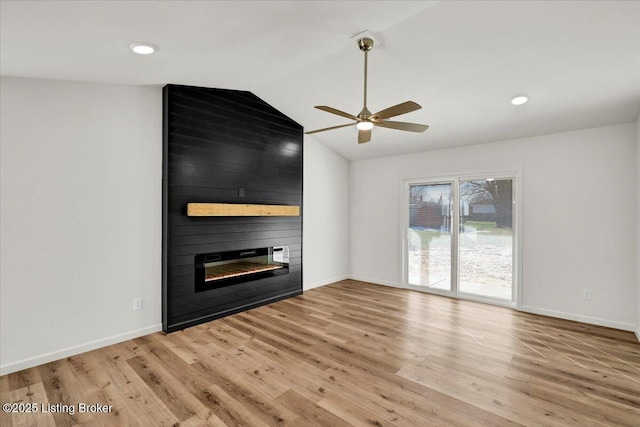 unfurnished living room featuring ceiling fan, lofted ceiling, light wood-type flooring, and a fireplace