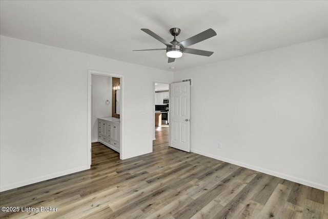 unfurnished bedroom featuring hardwood / wood-style flooring, ceiling fan, and connected bathroom