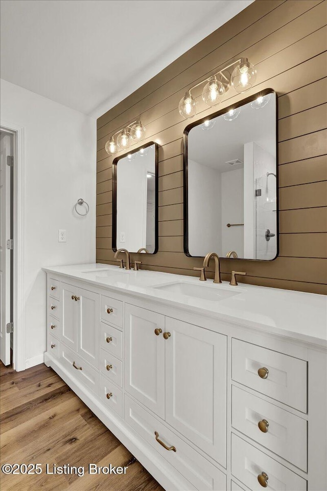 bathroom with vanity, hardwood / wood-style floors, and wood walls