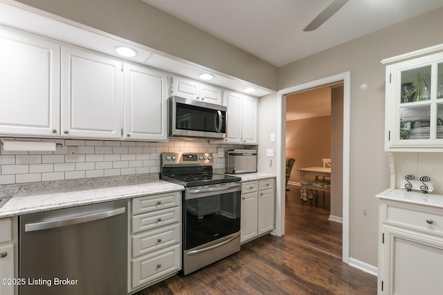 kitchen featuring white cabinetry, dark hardwood / wood-style flooring, ceiling fan, stainless steel appliances, and decorative backsplash