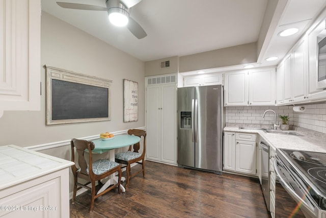 kitchen with white cabinetry, sink, dark hardwood / wood-style flooring, decorative backsplash, and stainless steel appliances