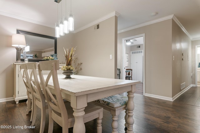 dining room with dark hardwood / wood-style flooring and ornamental molding