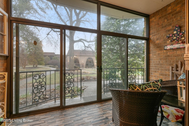 entryway with brick wall and a wall of windows