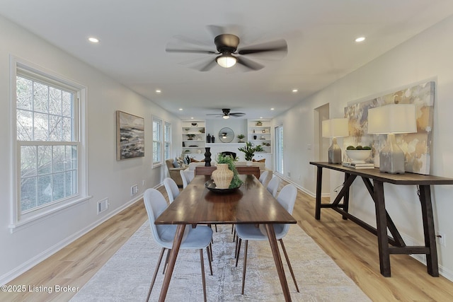 dining area with built in features and light hardwood / wood-style flooring