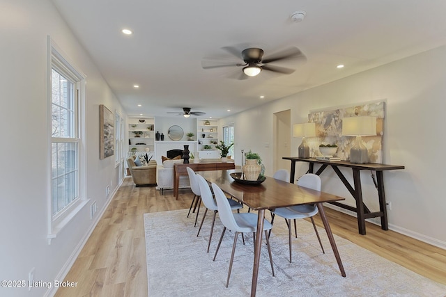 dining space with ceiling fan and light wood-type flooring