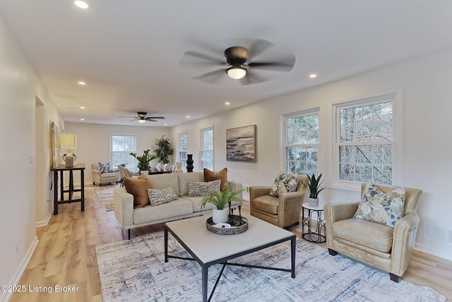 living room with ceiling fan and light hardwood / wood-style flooring