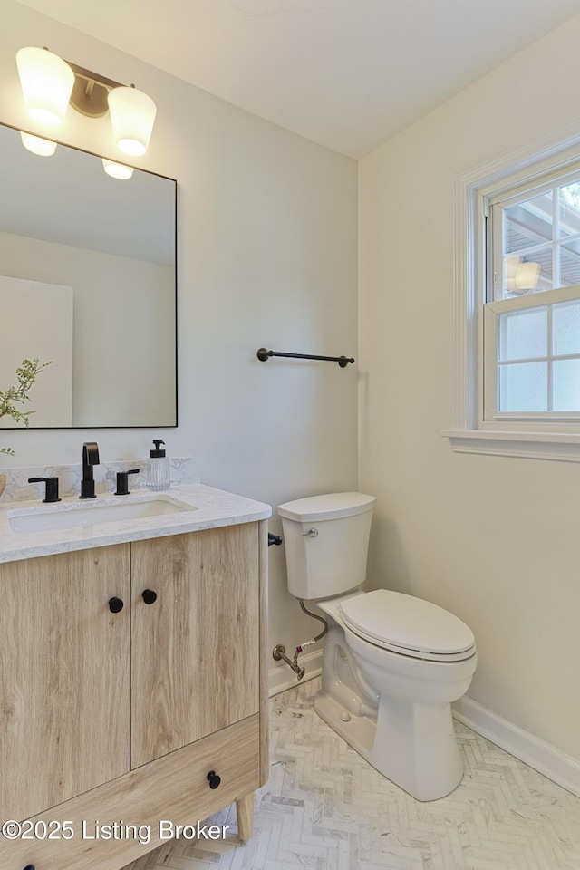 bathroom with vanity, parquet floors, and toilet