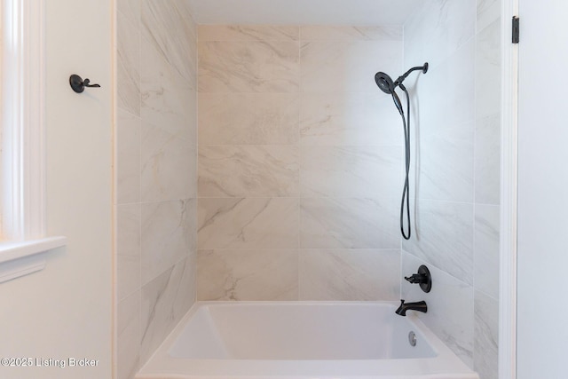 bathroom featuring tiled shower / bath