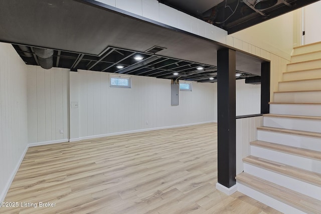 basement featuring hardwood / wood-style floors and electric panel