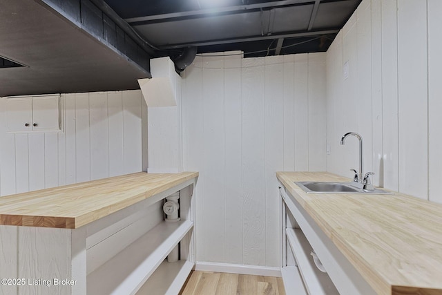 kitchen with wood counters, sink, and light wood-type flooring