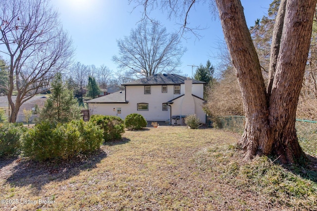 rear view of property featuring a lawn