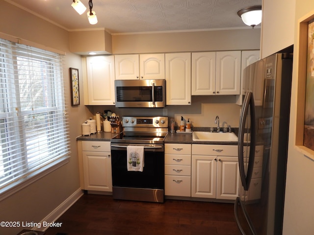 kitchen with dark wood-type flooring, appliances with stainless steel finishes, sink, and white cabinets