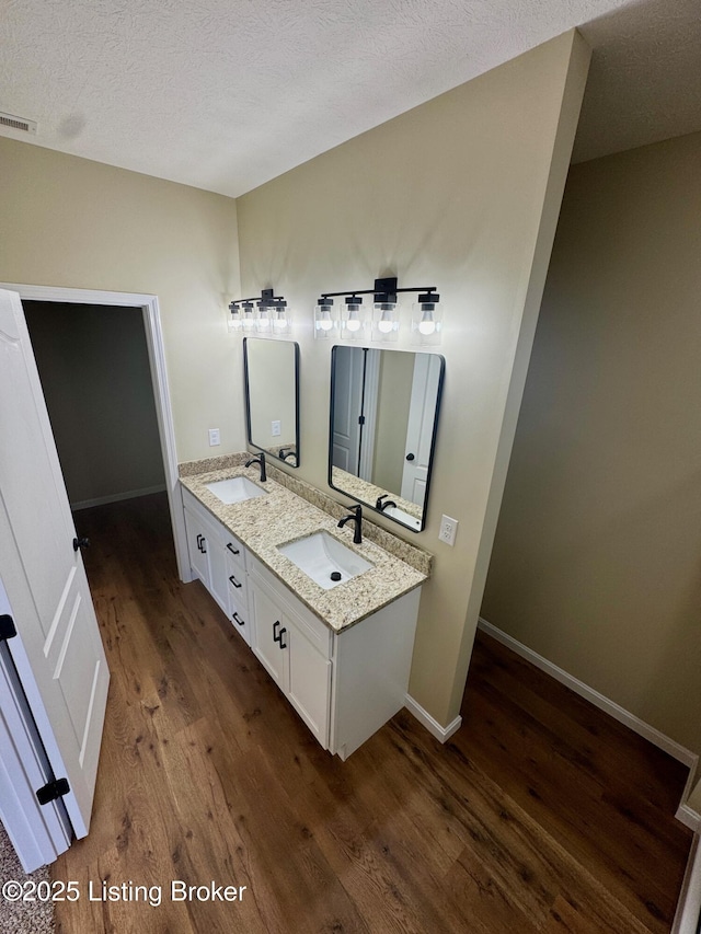 bathroom with vanity, hardwood / wood-style floors, and a textured ceiling