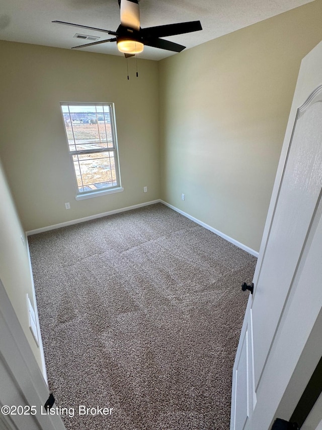 carpeted spare room featuring ceiling fan