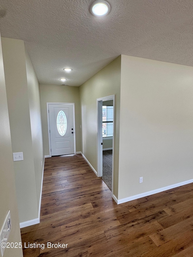 foyer featuring a textured ceiling and dark hardwood / wood-style flooring