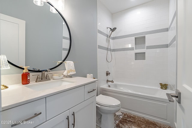 full bathroom featuring tiled shower / bath combo, vanity, and toilet