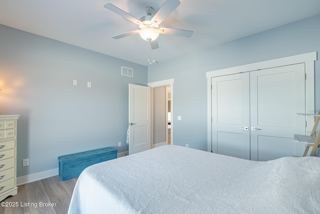 bedroom with ceiling fan, light hardwood / wood-style floors, and a closet