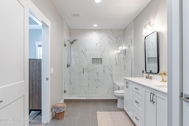 bathroom with toilet, vanity, and a shower with shower door