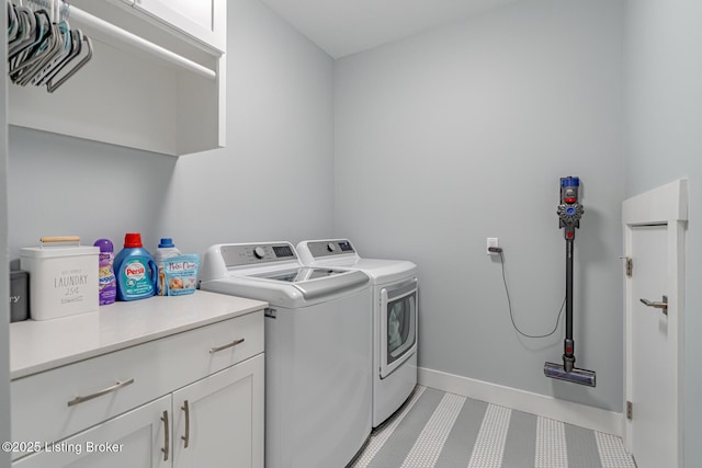 washroom featuring cabinets and separate washer and dryer