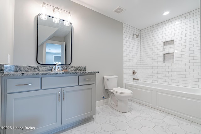 full bathroom featuring tiled shower / bath, vanity, toilet, and tile patterned flooring