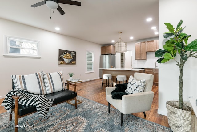 living room featuring ceiling fan and hardwood / wood-style floors