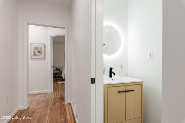 hall with wood-type flooring and sink