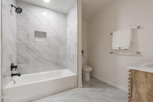 full bathroom featuring vanity, tiled shower / bath, and toilet