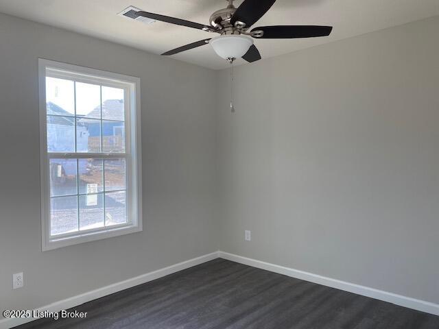 spare room featuring dark wood-type flooring and ceiling fan