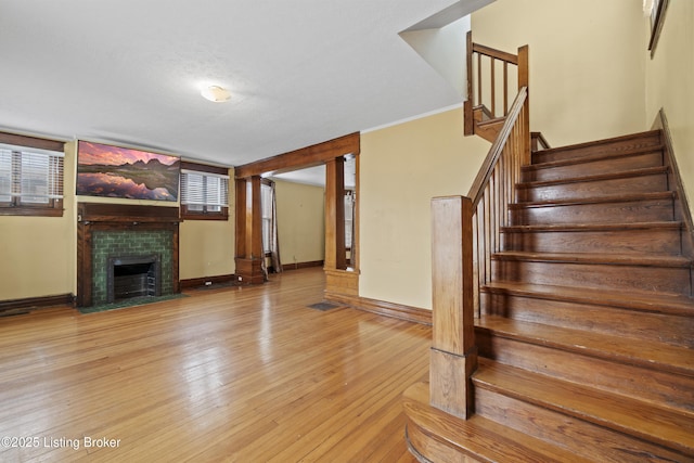 1615 Stevens Ave, Louisville, KY 40205 - stairway featuring a tile fireplace, wood finished floors, and baseboards