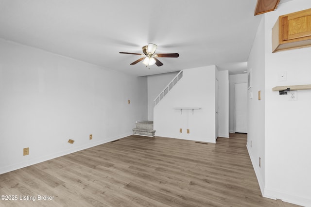 unfurnished living room featuring ceiling fan and hardwood / wood-style floors