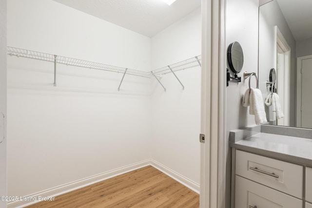 spacious closet featuring light hardwood / wood-style floors