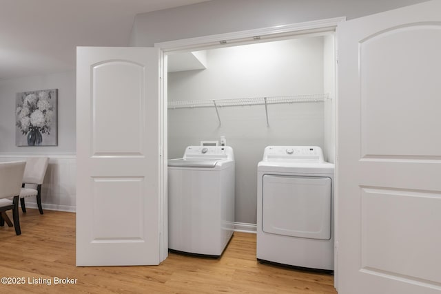 laundry room featuring independent washer and dryer and light hardwood / wood-style flooring